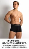 Calvin Kleinの限定モデル・ブラックのローライズボクサーパンツを着用した男性モデル。 ゴールドロゴが映えるデザインで、吸汗速乾のマイクロファイバー素材を使用。 商品名：3枚セット カルバンクライン CK Microfiber Plus メンズ下着。